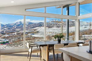 Sunroom / solarium with lofted ceiling, a mountain view, and a notable chandelier