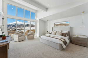 Carpeted bedroom with beamed ceiling and a towering ceiling