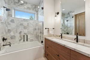 Bathroom with bath / shower combo with glass door and vanity