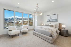 Bedroom featuring a mountain view, carpet floors, and a chandelier