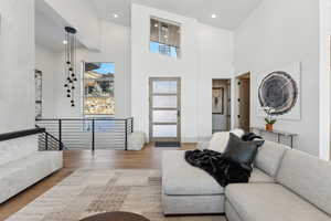 Living room with hardwood / wood-style flooring and high vaulted ceiling