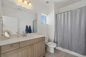 Bathroom featuring tile patterned flooring, vanity, and toilet