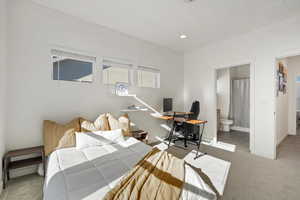 Carpeted bedroom featuring ensuite bath