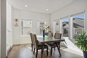 Dining area with hardwood / wood-style flooring and a healthy amount of sunlight