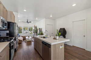 Kitchen with sink, appliances with stainless steel finishes, ceiling fan, a kitchen island with sink, and dark hardwood / wood-style flooring