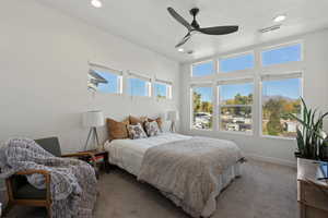 Bedroom featuring a textured ceiling, carpet, multiple windows, and ceiling fan