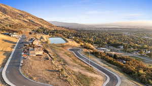Aerial view of property and surrounding area featuring a water and mountain view and nearby suburban area