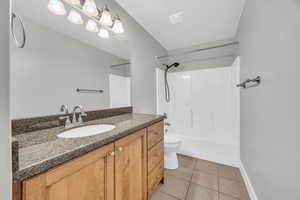 Full bathroom with tile patterned flooring, vanity,  shower combination, and toilet