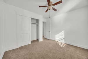 Unfurnished bedroom featuring ceiling fan, light carpet, and a closet