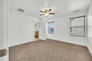 Unfurnished bedroom with ceiling fan, light carpet, and connected bathroom