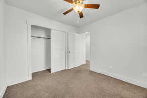 Unfurnished bedroom featuring carpet, a closet, and ceiling fan