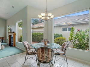 Dining area with light tile patterned floors and an inviting chandelier