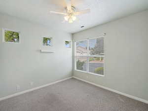 Bedroom featuring a textured ceiling, carpet flooring, and ceiling fan