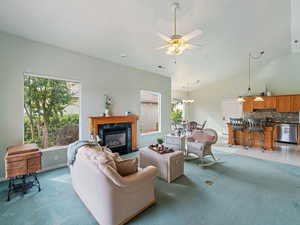 Carpeted living room featuring lofted ceiling, ceiling fan, and a high end fireplace