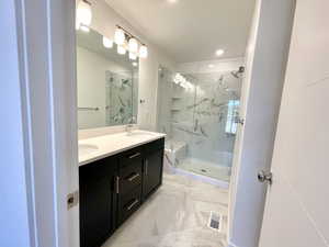 Step into a spa-like shower with clear glass doors and a convenient bench, perfect for relaxing after a day outdoors.