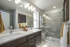 Step into a spa-like shower with clear glass doors and a convenient bench, perfect for relaxing after a day outdoors.