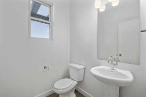 Bathroom with hardwood / wood-style floors, toilet, and sink