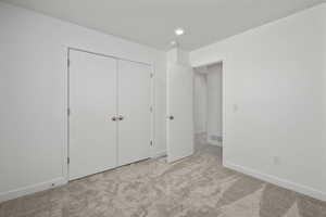 Unfurnished bedroom featuring light colored carpet and a closet