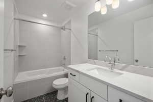 Full bathroom featuring vanity, toilet, and tiled shower / bath combo