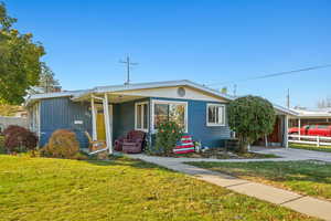 View of front of home with a porch, central AC, and a front lawn