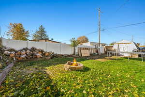 View of yard featuring an outdoor fire pit and a storage unit