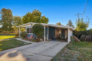 View of front of property with a carport and a front yard