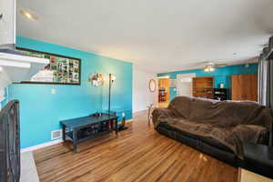 Living room with ceiling fan and wood-type flooring