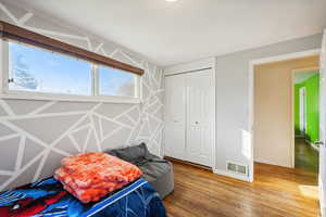 Bedroom with hardwood / wood-style floors and a closet