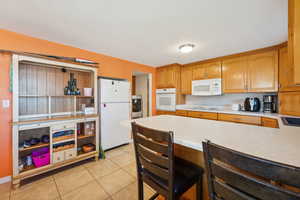 Kitchen featuring white appliances, washer / dryer, and light tile patterned floors