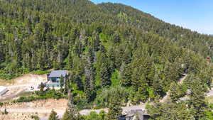 Aerial view of property and surrounding area with a heavily wooded area