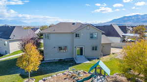 Back of property with a lawn and a mountain view