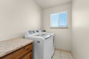 Washroom featuring light tile patterned floors and separate washer and dryer