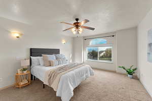 Carpeted bedroom featuring a textured ceiling and ceiling fan