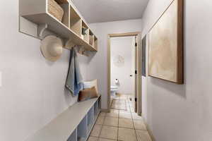 Mudroom with a textured ceiling and light tile patterned floors