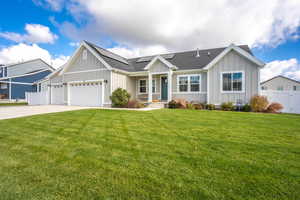 Ranch-style house featuring a garage and a front lawn