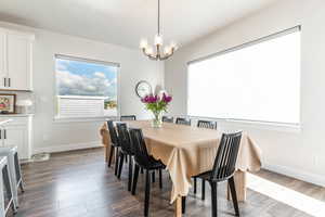 Dining area with dark wood-type flooring and a chandelier