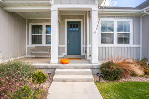 Doorway to property featuring covered porch