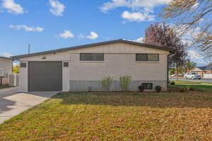 View of side of home featuring a garage and a yard