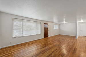 Foyer entrance featuring a textured ceiling and light hardwood / wood-style floors