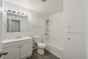 Full bathroom featuring toilet, vanity, shower / bathtub combination