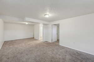 Carpeted empty room featuring a textured ceiling