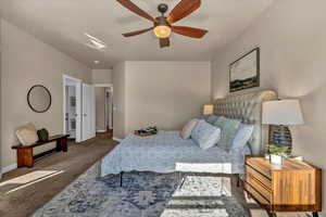 Bedroom with ceiling fan and dark carpet