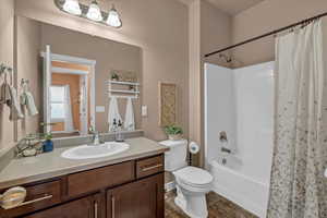 Full bathroom featuring vanity, toilet, and shower / bathtub combination with curtain