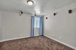 Carpeted spare room featuring a textured ceiling