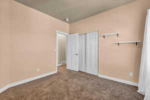 Unfurnished bedroom with a closet and carpet floors