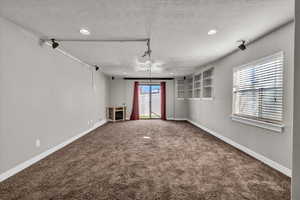 Interior space featuring built in features, a textured ceiling, and carpet floors