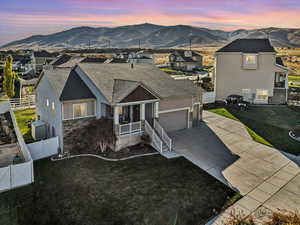 View of front of house featuring a garage, a mountain view, and a yard