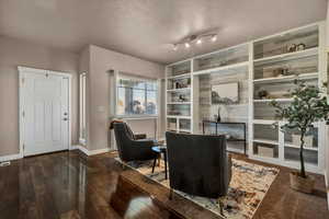 Living area featuring built in features and dark hardwood / wood-style flooring