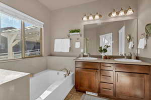 Bathroom with vanity, tile patterned floors, and a bathing tub