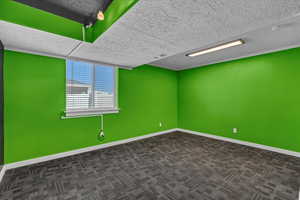 Carpeted empty room featuring a textured ceiling